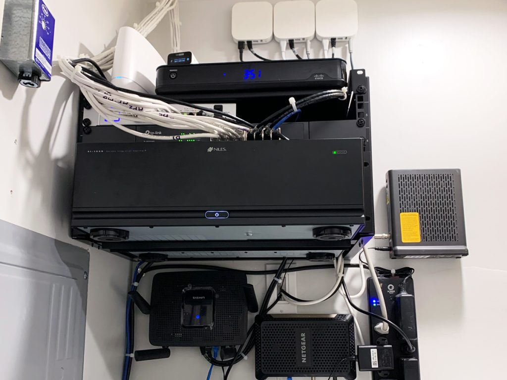 A rack holding an audio receiver, routers, modems and air play